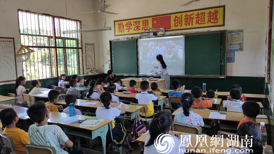 (图为志愿者为小朋友们讲解歌曲背后的故事 刘雅璐 摄)