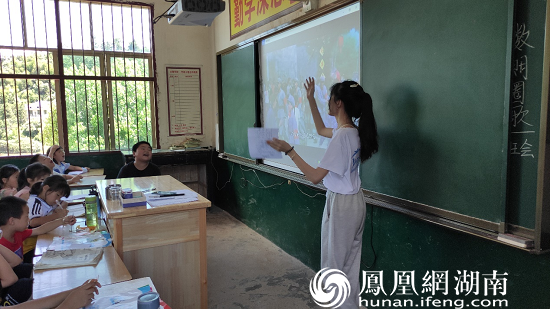 (图为志愿者在教小朋友唱《红星闪闪》 刘雅璐 摄)