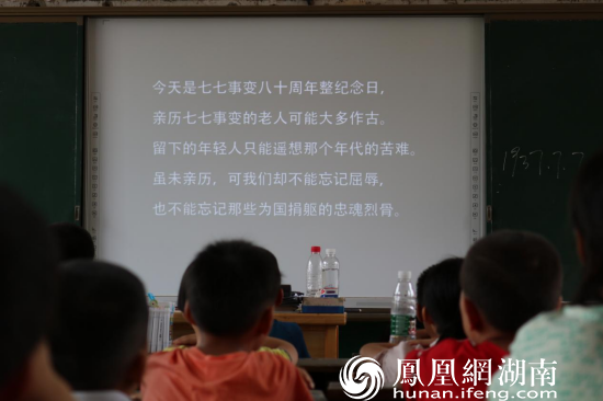 图为志愿者通过课件形式教导孩子们要牢记国耻 陈芊桦摄
