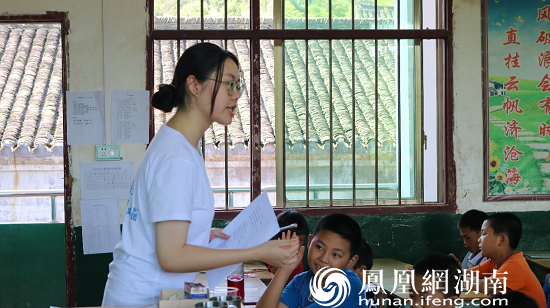 (图为志愿者为小朋友讲解诗歌的意义 康博英 摄)